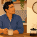 Ilustración de un hombre sonriente tomando café en una cocina cálida y luminosa mientras mira un reloj de pared.