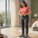 Mujer de mediana edad se pesa en una báscula digital mientras ajusta el pantalón en un dormitorio luminoso.
