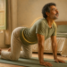 Hombre adulto realizando un estiramiento de espalda a cuatro apoyos sobre una esterilla en el dormitorio, con una línea luminosa que resalta la zona lumbar.