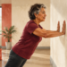 Mujer mayor realiza flexiones de brazos contra la pared, con las manos apoyadas y el cuerpo inclinado hacia delante.