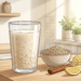 Ilustración de un vaso de agua de avena junto a un tazón con hojuelas, limones y canela sobre una encimera en una cocina luminosa.