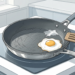 Ilustración de una sartén antiadherente rayada y con el revestimiento descascarado sobre una placa de cocina, friendo un huevo con una espátula de madera al lado.