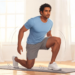 Un hombre en ropa deportiva se levanta de una colchoneta de yoga en el suelo sin usar las manos, ejecutando una prueba de movilidad y equilibrio corporal.