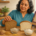 Mujer adulta comparando dos panes de molde, uno integral y otro blanco, junto a bolsas de pan, granos, semillas y harinas sobre una mesa de cocina.