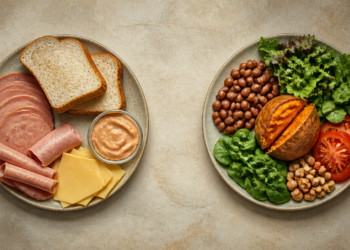 Dos platos vistos desde arriba sobre una superficie clara: uno con pan blanco, embutidos, queso y una salsa cremosa, y otro con frijoles, verduras de hoja, tomate, nueces y batata asada.