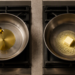 Dos sartenes sobre una cocina de gas: una con aceite de oliva vertido desde una cuchara y otra con un trozo de mantequilla derritiéndose.