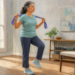 Mujer mayor realizando un ejercicio de equilibrio en casa con una banda elástica apoyada sobre los hombros y una pierna elevada.
