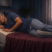 Hombre adulto durmiendo de lado en una cama con una almohada bajo la cabeza y otra entre las piernas, en una postura de descanso nocturno.