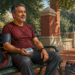 Hombre de mediana edad descansa en un banco de parque mientras mide su presión arterial con un brazalete y un monitor portátil después de hacer ejercicio.