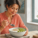 Mujer preparando un desayuno con yogur, copos de avena, kiwi y semillas de chía, acompañado por un vaso de agua sobre una mesa de cocina.