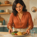 Mujer adulta colocando sobre una encimera un plato con huevos, aguacate, verduras y pan integral, junto a un vaso de agua en una cocina luminosa.