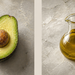 Mitad de aguacate con hueso y una jarra de aceite sobre una superficie clara, presentados en una composición dividida en dos partes.