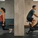 Mujer realizando una zancada con mancuernas y hombre pedaleando en una bicicleta estática dentro de un gimnasio.