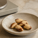 Cuenco con varias nueces de Brasil sobre una encimera clara, junto a una balanza de cocina.