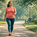 Mujer adulta caminando a paso ligero por un parque, con ropa deportiva y zapatillas, rodeada de árboles y vegetación.
