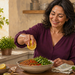 Mujer en una cocina exprimiendo medio limón sobre un bol con legumbres y verduras frescas, junto a tomates, pimientos y hierbas aromáticas.