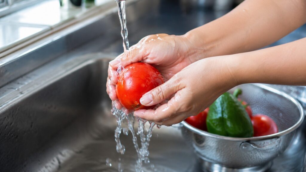 Lavar bem os alimentos é uma medida simples para reduzir sujeiras e parte dos resíduos superficiais.